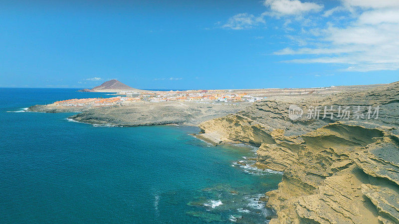 Aerial view of the coast in the natural reserve of "Montaña Pelada" and town of El Medano in the background. Tenerife, Canary Islands. Drone shot